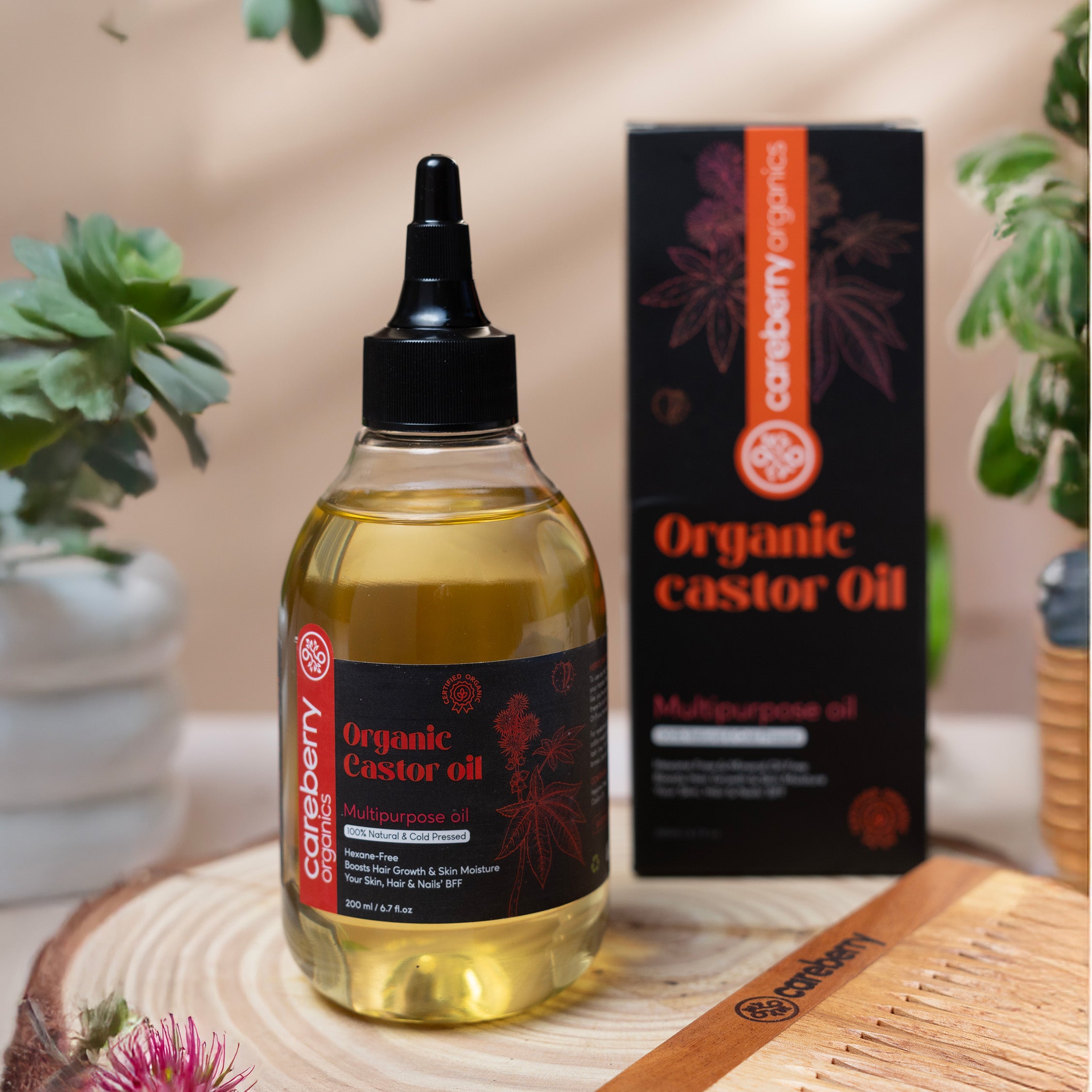 Careberry Organic Castor Oil bottle placed beside its black and orange packaging on a natural wooden setup.